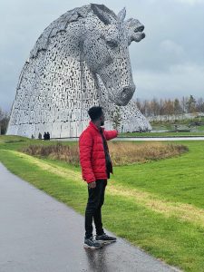 Scholar standing in front of horse sculpture
